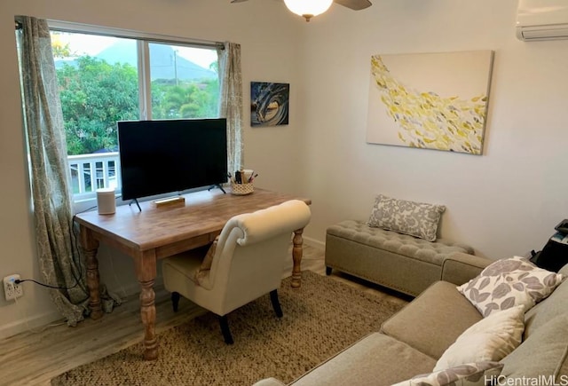 office space with a wall mounted AC, wood finished floors, a wealth of natural light, and baseboards