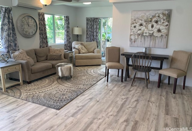 living area with a wall mounted air conditioner, ceiling fan, and wood finished floors