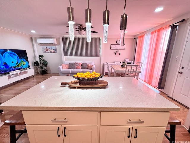 91-692 Kilinahe St, Ewa Beach, HI 96706 - kitchen featuring light stone countertops, a breakfast bar area, a kitchen island, a wall mounted air conditioner, and open floor plan