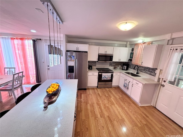 91-692 Kilinahe St, Ewa Beach, HI 96706 - kitchen with backsplash, a sink, light wood-style floors, appliances with stainless steel finishes, and white cabinetry