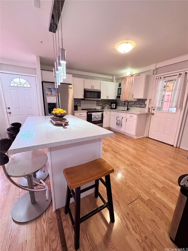 91-692 Kilinahe St, Ewa Beach, HI 96706 - kitchen with a breakfast bar area, light countertops, appliances with stainless steel finishes, and hanging light fixtures