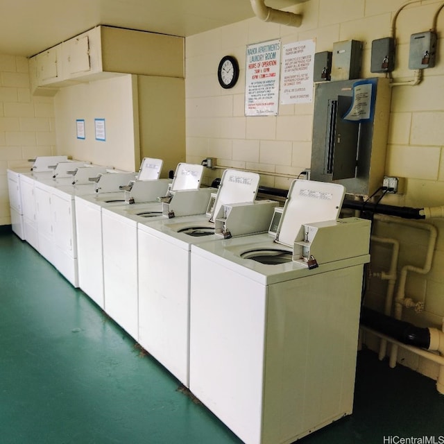 shared laundry area with washer and clothes dryer and concrete block wall