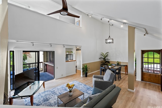 46-058 Aliikane Pl Unit 2123, Kaneohe, HI 96744 - living area with track lighting, healthy amount of natural light, wood finished floors, a wainscoted wall, and high vaulted ceiling