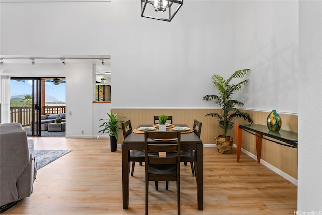 46-058 Aliikane Pl Unit 2123, Kaneohe, HI 96744 - dining room featuring light wood finished floors, a wainscoted wall, rail lighting, baseboards, and a chandelier
