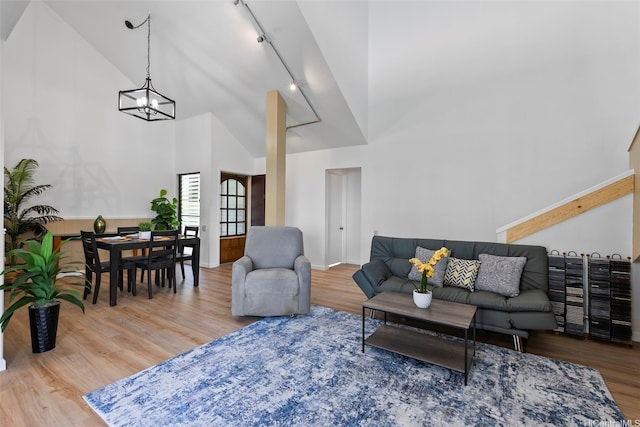 46-058 Aliikane Pl Unit 2123, Kaneohe, HI 96744 - living room featuring high vaulted ceiling, rail lighting, wood finished floors, and a chandelier