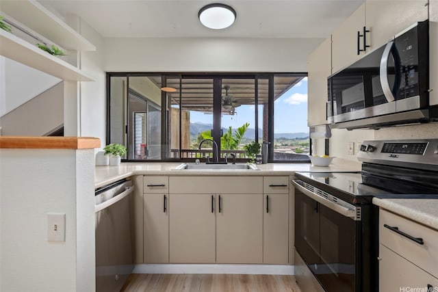 46-058 Aliikane Pl Unit 2123, Kaneohe, HI 96744 - kitchen with stainless steel appliances, a sink, light countertops, and light wood-style floors