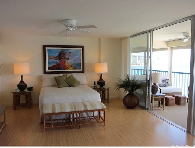 bedroom with baseboards, wood finished floors, and access to exterior