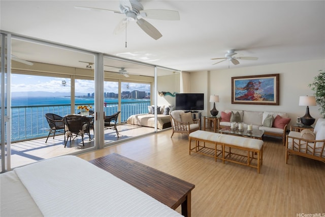 2877 Kalakaua Ave Unit 1105, Honolulu, HI 96815 - living room featuring a wall of windows, a water view, wood finished floors, and ceiling fan