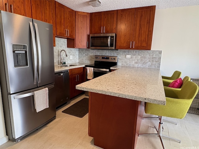 2140 Kuhio Ave Unit 911, Honolulu, HI 96815 - kitchen with a sink, a peninsula, a textured ceiling, decorative backsplash, and appliances with stainless steel finishes