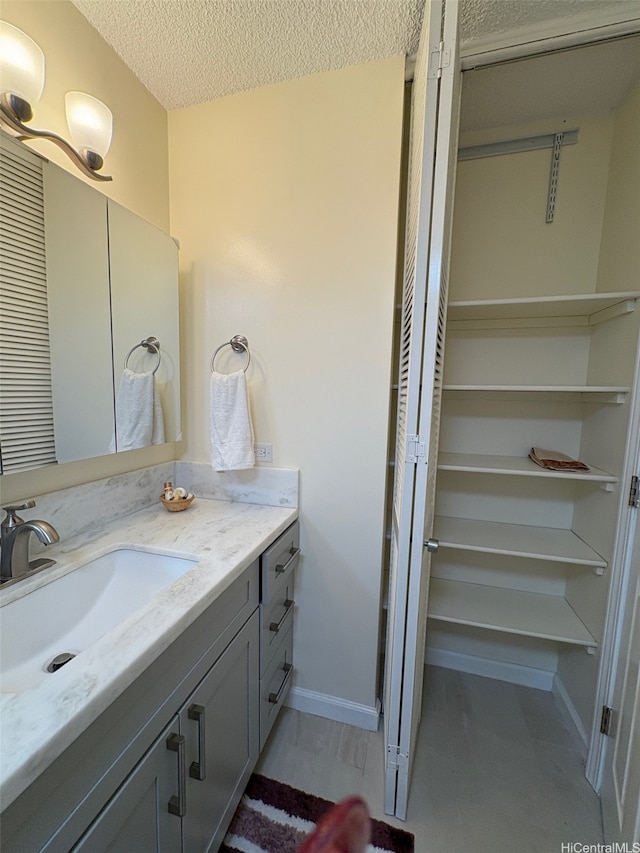 2140 Kuhio Ave Unit 911, Honolulu, HI 96815 - bathroom with baseboards, vanity, and a textured ceiling