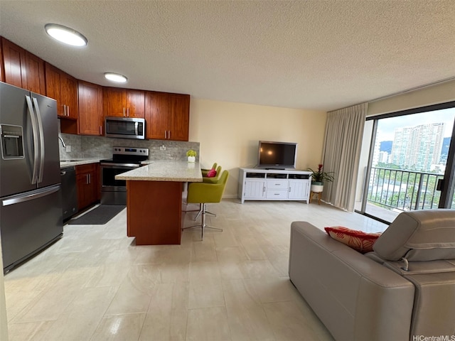 2140 Kuhio Ave Unit 911, Honolulu, HI 96815 - kitchen featuring a breakfast bar, a peninsula, open floor plan, decorative backsplash, and stainless steel appliances