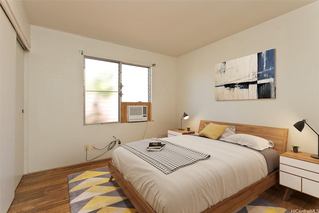 bedroom featuring wood finished floors, cooling unit, and a closet