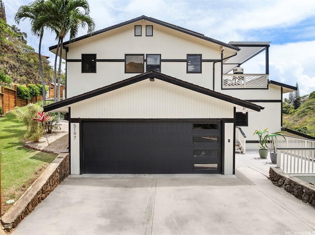 view of front of home with a garage, a balcony, and driveway