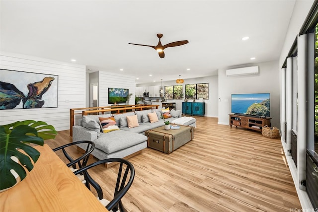 living room with light wood finished floors, ceiling fan, recessed lighting, and an AC wall unit