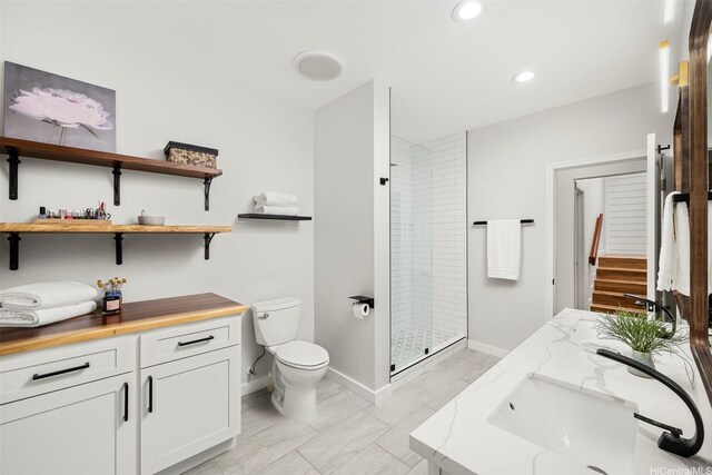 bathroom with recessed lighting, a shower stall, toilet, vanity, and baseboards