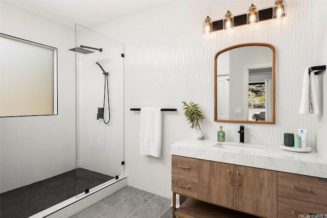 bathroom with walk in shower, vanity, and tile patterned flooring