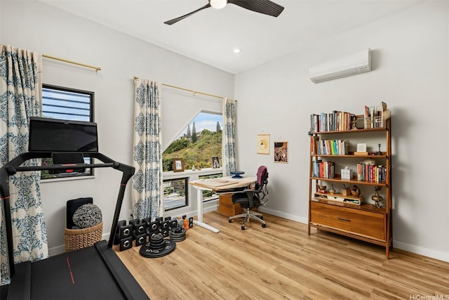 office area with baseboards, a wall unit AC, ceiling fan, and plenty of natural light