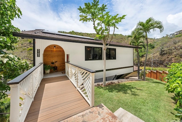 exterior space featuring roof mounted solar panels and a yard
