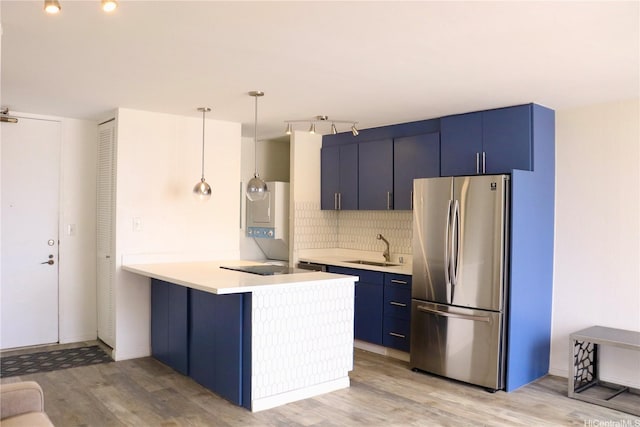 320 Liliuokalani Ave Unit 902, Honolulu, HI 96815 - kitchen with freestanding refrigerator, blue cabinetry, a peninsula, decorative backsplash, and light wood finished floors