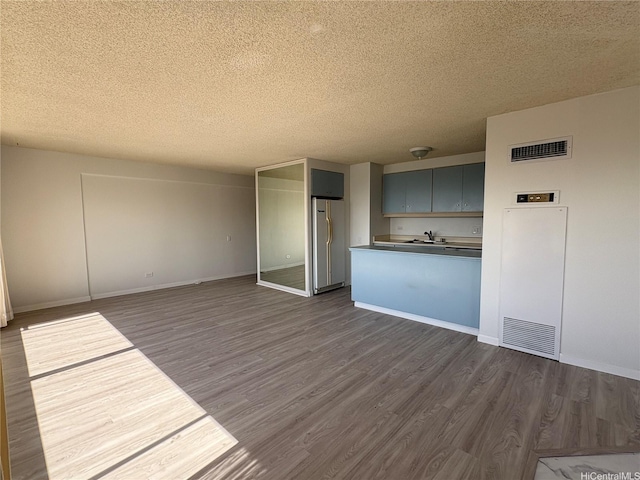 1778 Ala Moana Blvd Unit 3616, Honolulu, HI 96815 - unfurnished living room with a textured ceiling, dark wood-type flooring, a sink, and baseboards