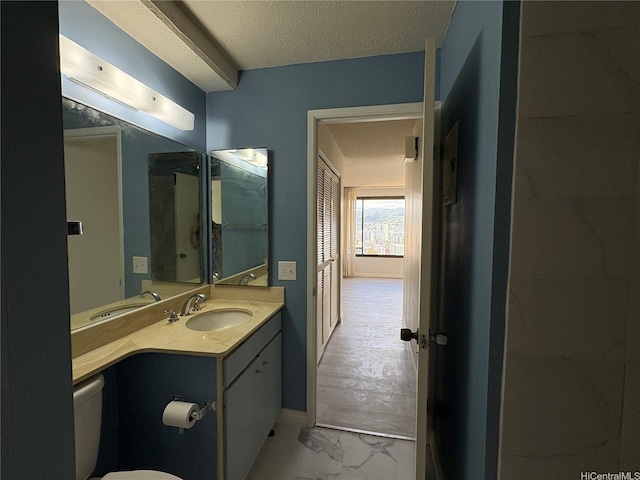 1778 Ala Moana Blvd Unit 3616, Honolulu, HI 96815 - bathroom with vanity, marble look tile flooring, toilet, baseboards, and a textured ceiling