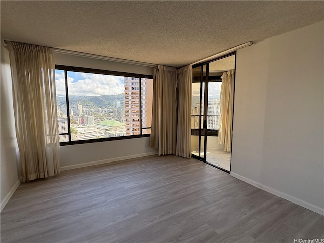 1778 Ala Moana Blvd Unit 3616, Honolulu, HI 96815 - spare room featuring a textured ceiling, plenty of natural light, wood finished floors, and a city view