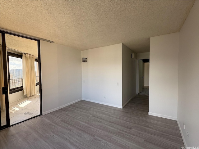 1778 Ala Moana Blvd Unit 3616, Honolulu, HI 96815 - unfurnished room featuring wood finished floors, a textured ceiling, and baseboards