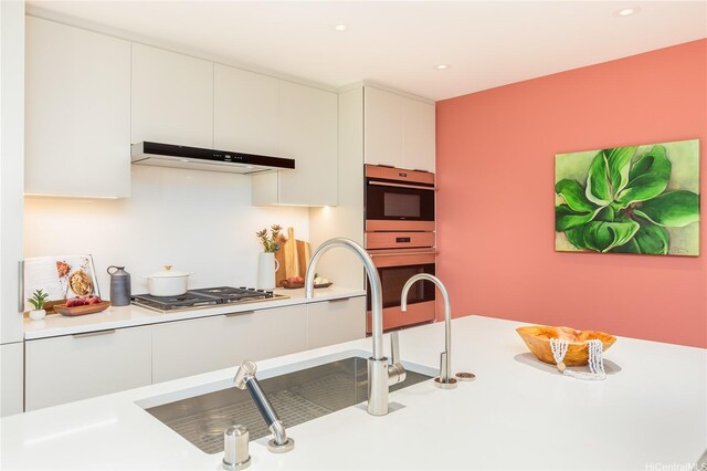 1388 Ala Moana Blvd Unit 1405, Honolulu, HI 96814 - kitchen with under cabinet range hood, stainless steel appliances, white cabinets, light countertops, and recessed lighting