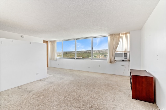 empty room with a textured ceiling, carpet flooring, and cooling unit