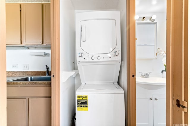 washroom featuring stacked washer and dryer and a sink