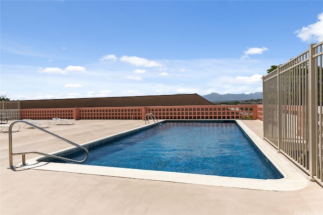 view of swimming pool with a mountain view, fence, a patio area, and a fenced in pool