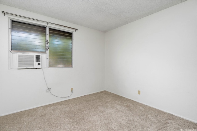carpeted empty room featuring a textured ceiling, cooling unit, and baseboards