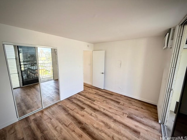 2122 Lime St Unit 604, Honolulu, HI 96826 - unfurnished bedroom featuring wood finished floors, baseboards, and a wall mounted AC