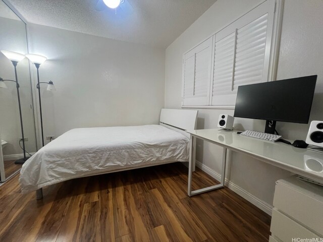 bedroom featuring dark wood-style flooring and baseboards