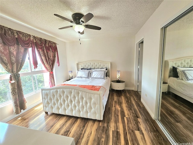 bedroom with baseboards, wood finished floors, a ceiling fan, and a textured ceiling