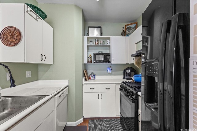 kitchen with black appliances, a sink, open shelves, light countertops, and white cabinets