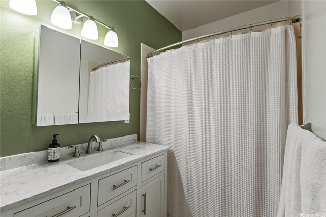 bathroom featuring vanity and a textured wall
