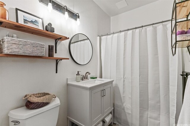 bathroom with toilet, vanity, and curtained shower
