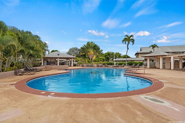 community pool with a gazebo and a patio area