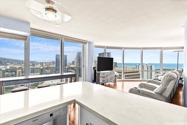 1296 Kapiolani Blvd Unit 3403, Honolulu, HI 96814 - kitchen featuring stainless steel dishwasher, open floor plan, floor to ceiling windows, wood finished floors, and a textured ceiling