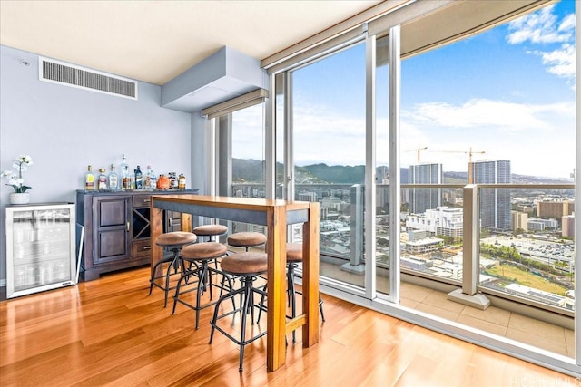 1296 Kapiolani Blvd Unit 3403, Honolulu, HI 96814 - dining area with wine cooler, a dry bar, wood finished floors, expansive windows, and a view of city