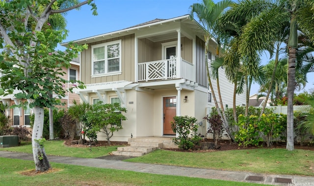 91-2141 Kaiwawalo St, Ewa Beach, HI 96706 - view of property featuring a balcony, board and batten siding, a front yard, and stucco siding