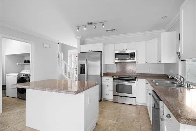 91-2141 Kaiwawalo St, Ewa Beach, HI 96706 - kitchen with appliances with stainless steel finishes, a sink, washer and dryer, light tile patterned floors, and crown molding