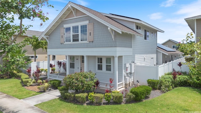 view of front of home with fence, covered porch, and a front lawn