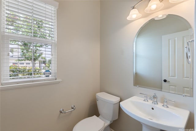 half bathroom featuring toilet and a sink