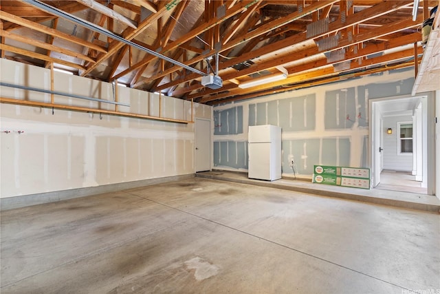garage featuring a garage door opener and freestanding refrigerator