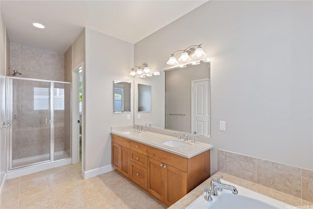 bathroom with a stall shower, tile patterned flooring, double vanity, and a sink