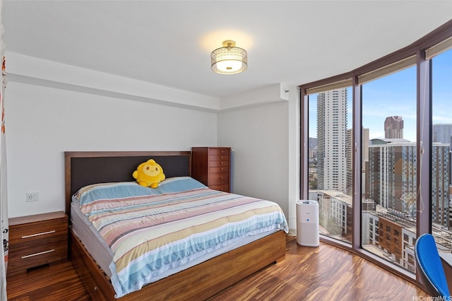bedroom with expansive windows and wood finished floors