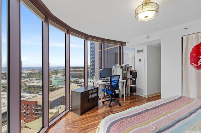 bedroom featuring visible vents, wood finished floors, and multiple windows