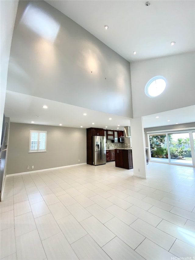 98-1810 Kaahumanu St Unit 3, Pearl City, HI 96782 - unfurnished living room with a towering ceiling, recessed lighting, light tile patterned floors, and baseboards